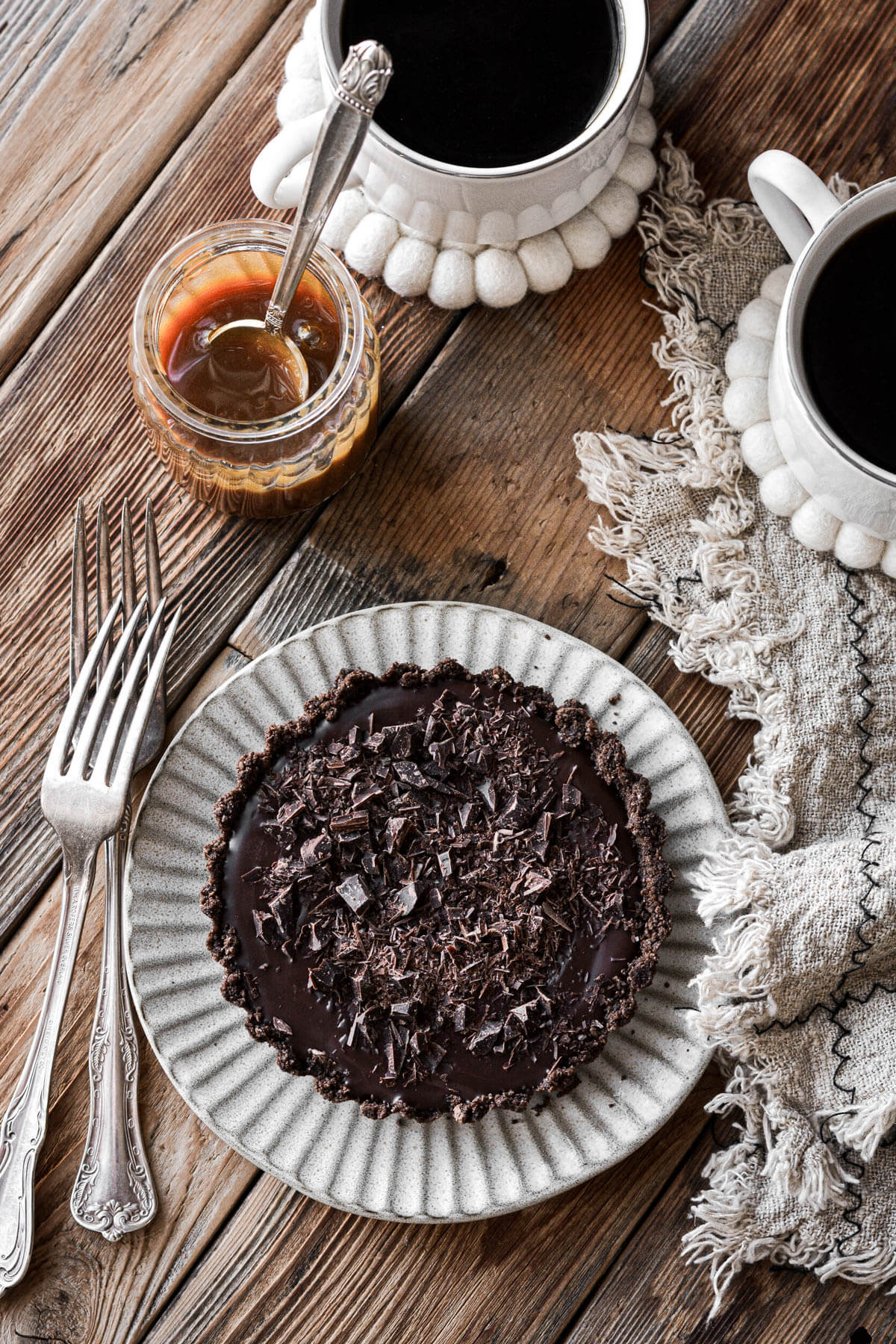 Mini chocolate tart with cups of coffee.