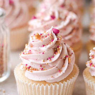 Vanilla cupcake with pink raspberry buttercream and valentines sprinkles.