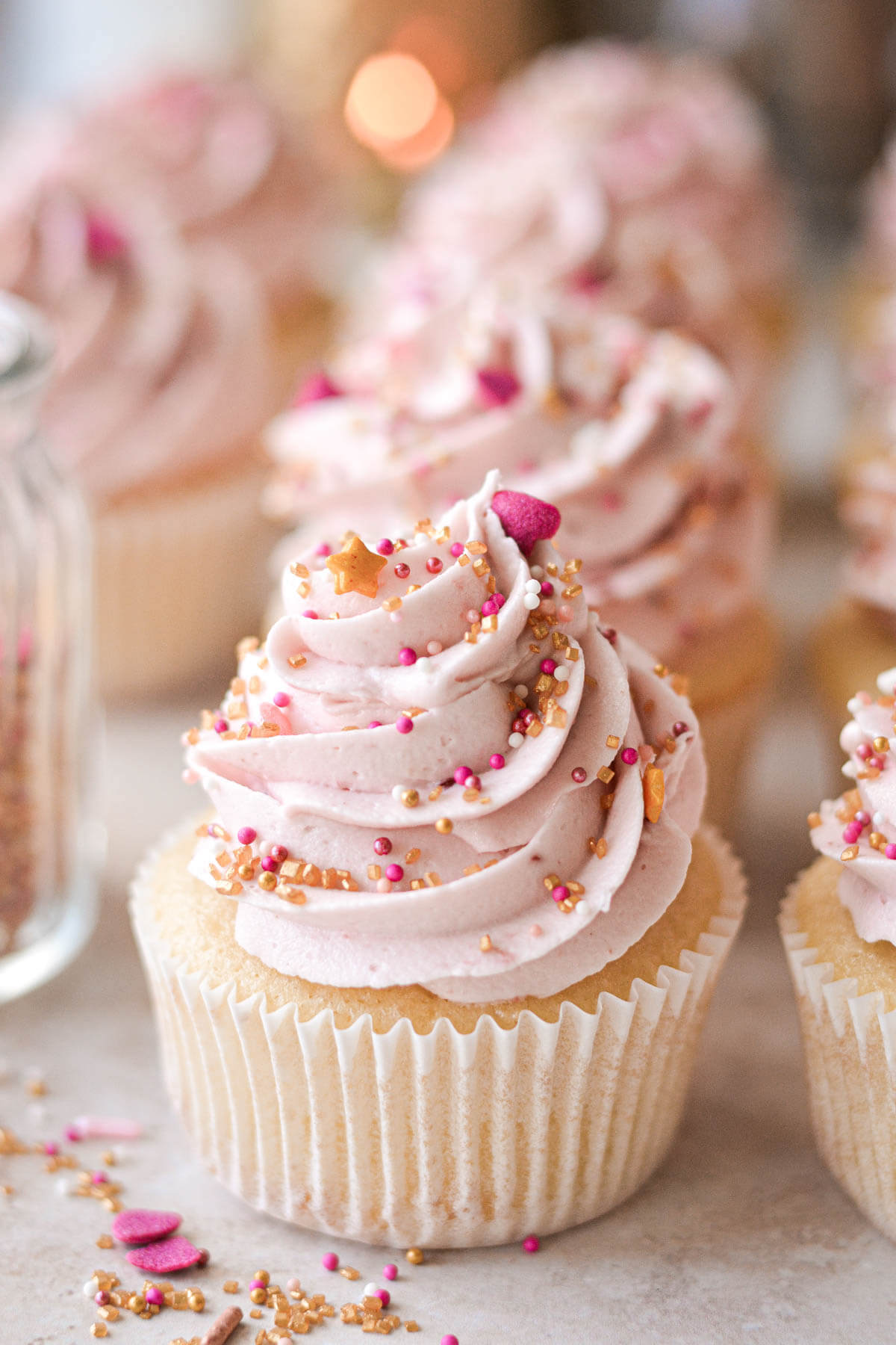 Vanilla cupcake with pink raspberry buttercream and valentines sprinkles.