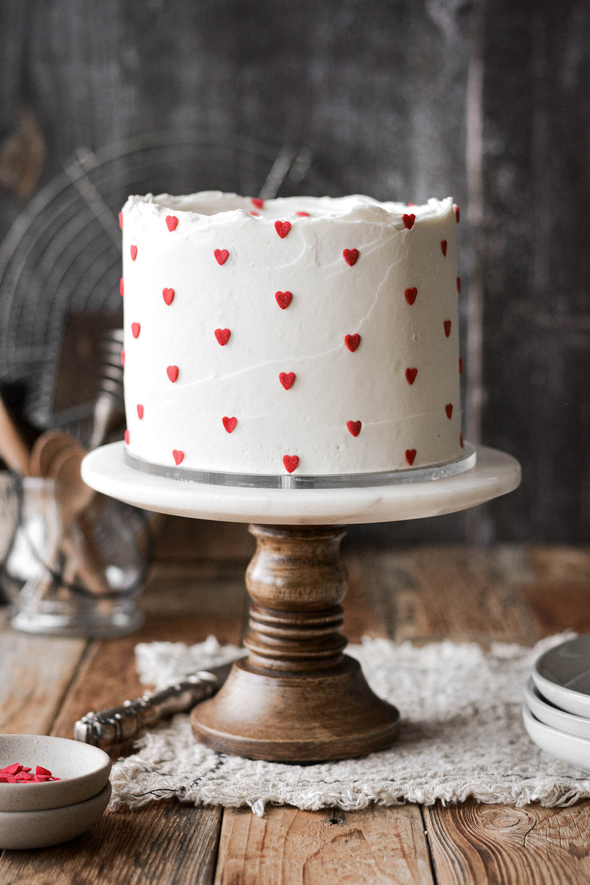 Valentine's Day cake with white buttercream and red heart sprinkles.