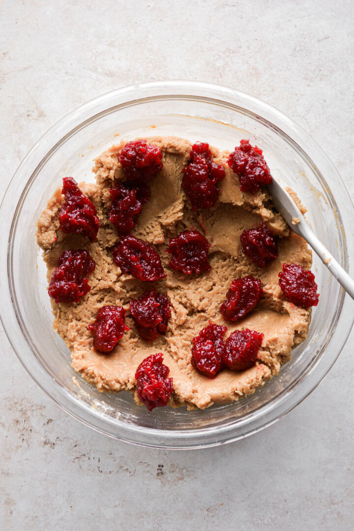 Peanut butter cookie dough with dollops of strawberry jam.