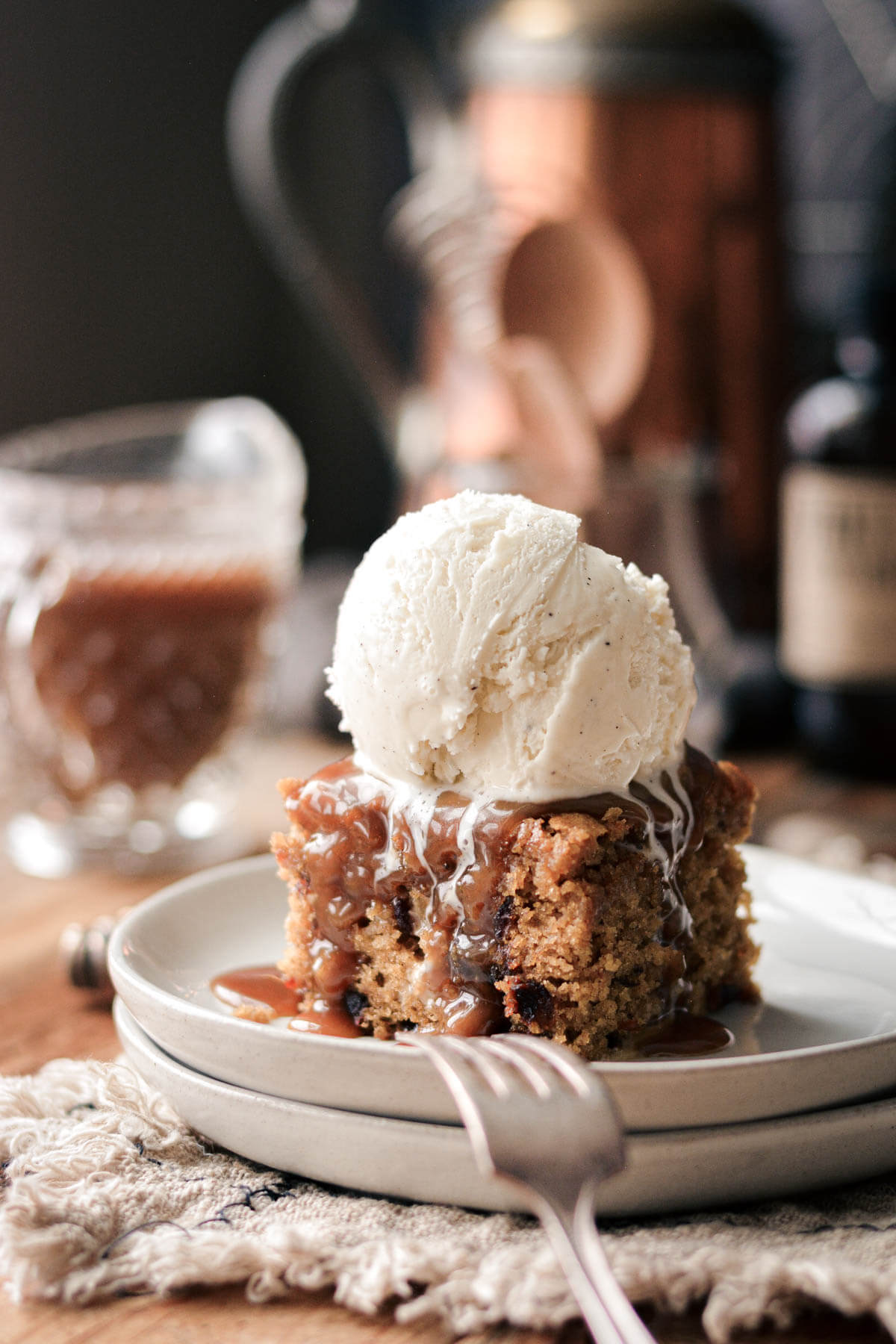 Sticky toffee pudding topped with toffee sauce and vanilla ice cream.