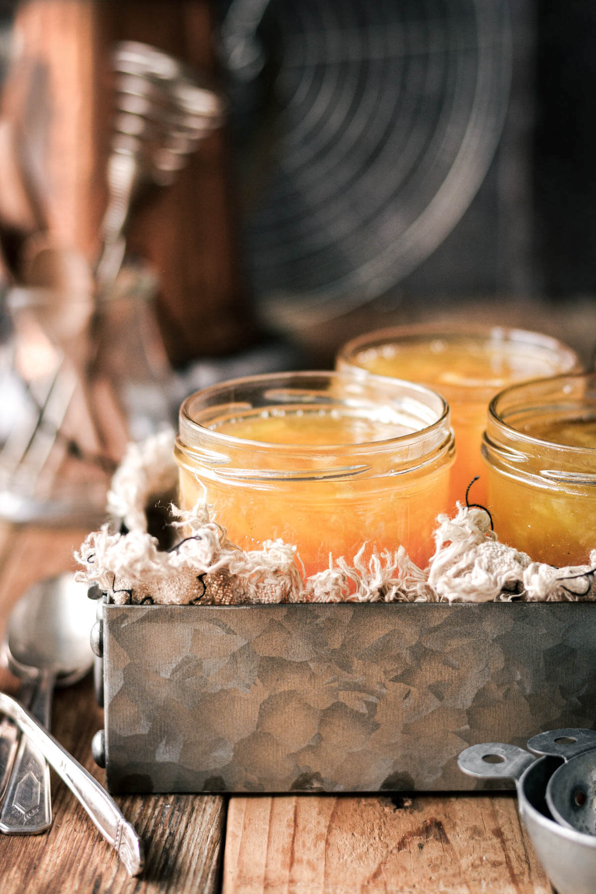 Jars of lemon marmalade in a metal tray.