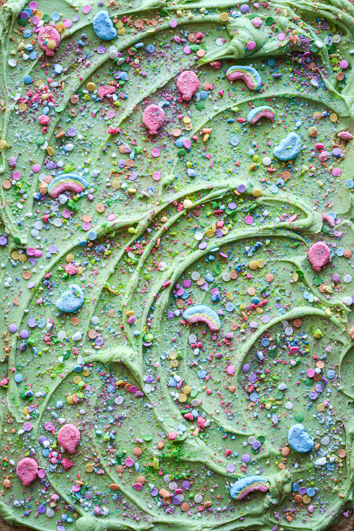 Green frosting with sprinkles and Lucky Charms marshmallows.