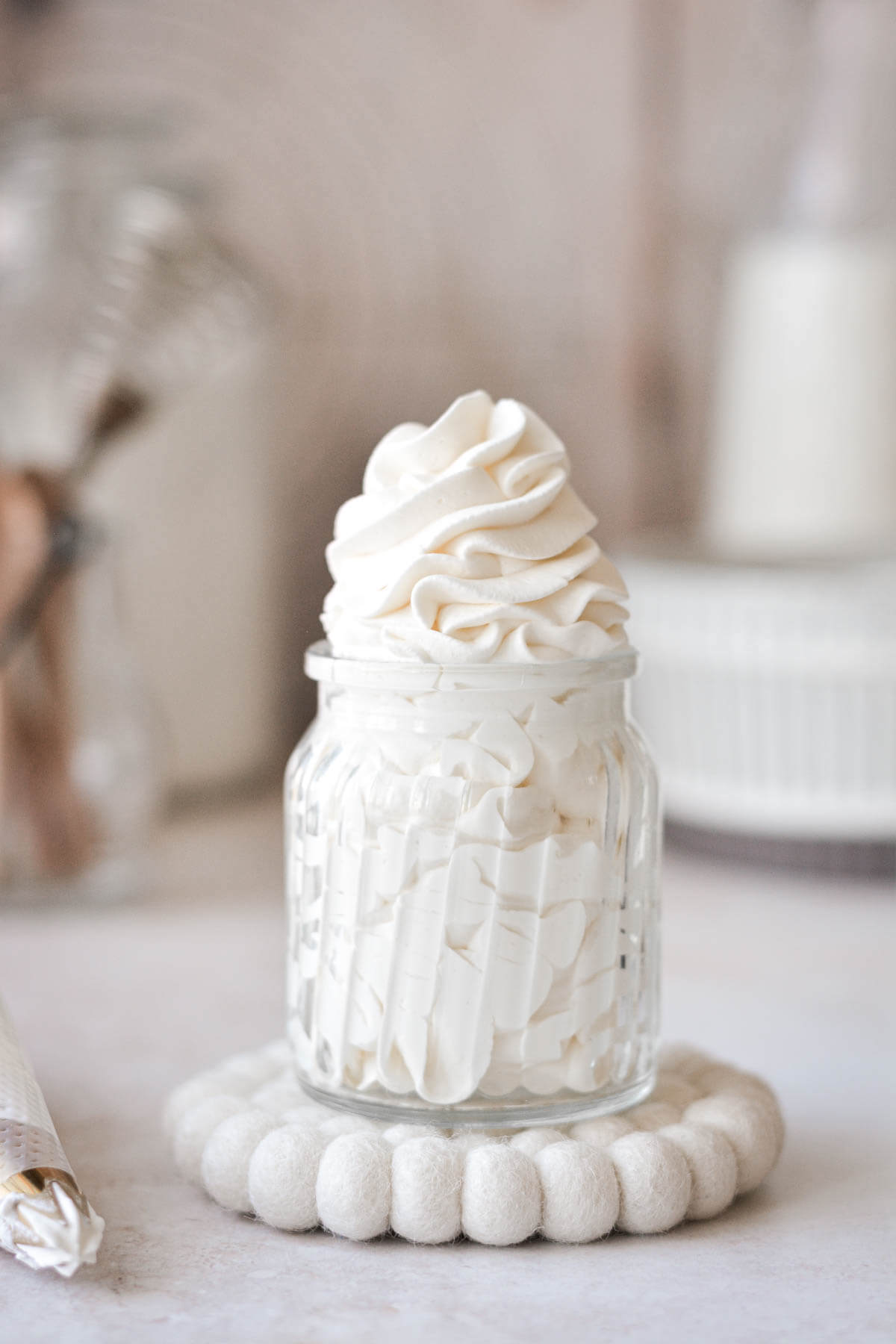 Homemade stabilized whipped cream, piped into a glass jar.