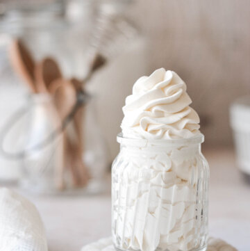 Homemade stabilized whipped cream, piped into a glass jar.