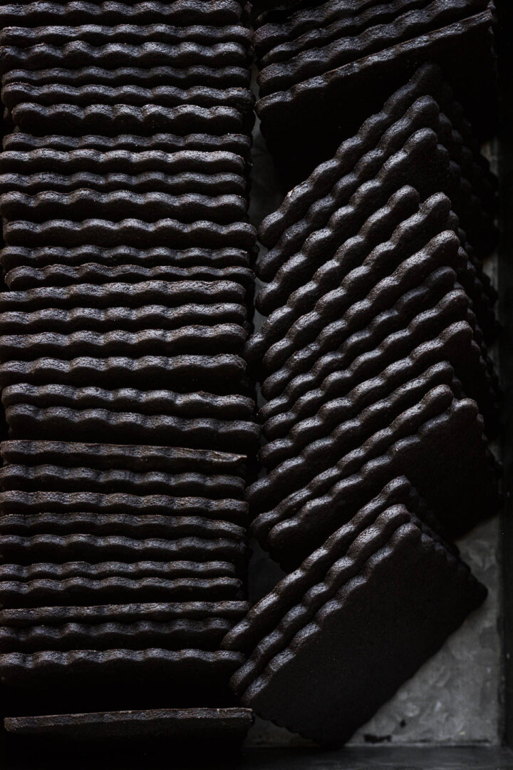 Homemade chocolate wafer cookies, lined up to show the edges.