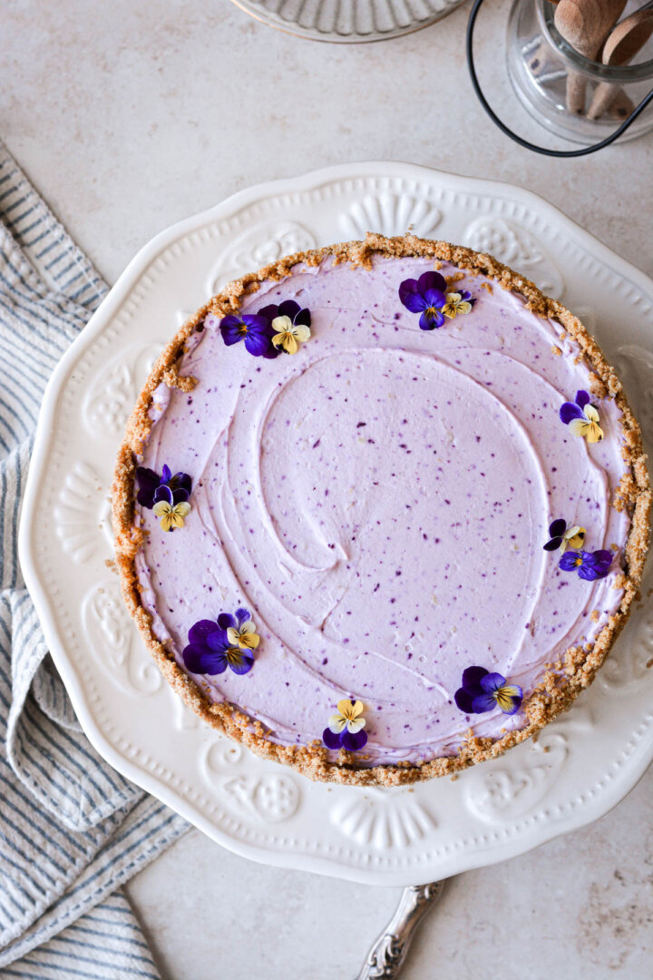 Lemon blueberry cheesecake decorated with fresh pansies.