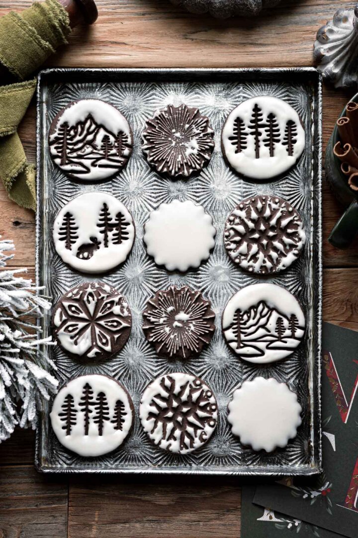 Iced chocolate gingerbread Christmas cookies on a baking sheet.