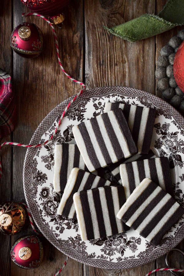 Square shaped striped chocolate and vanilla sugar cookies on a plate.
