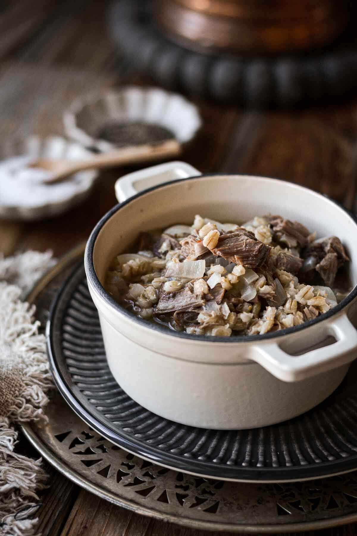 Beef and barley soup in a mini white Dutch oven.