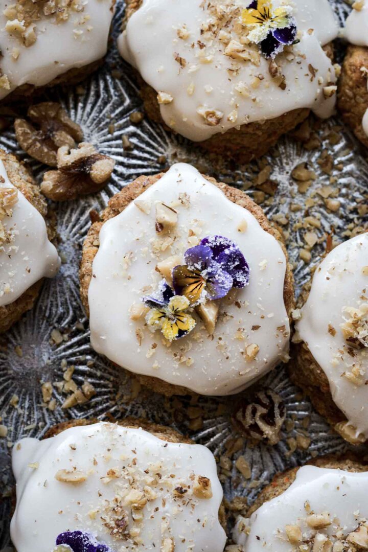 Carrot cake scones with vanilla icing and sugared flowers.