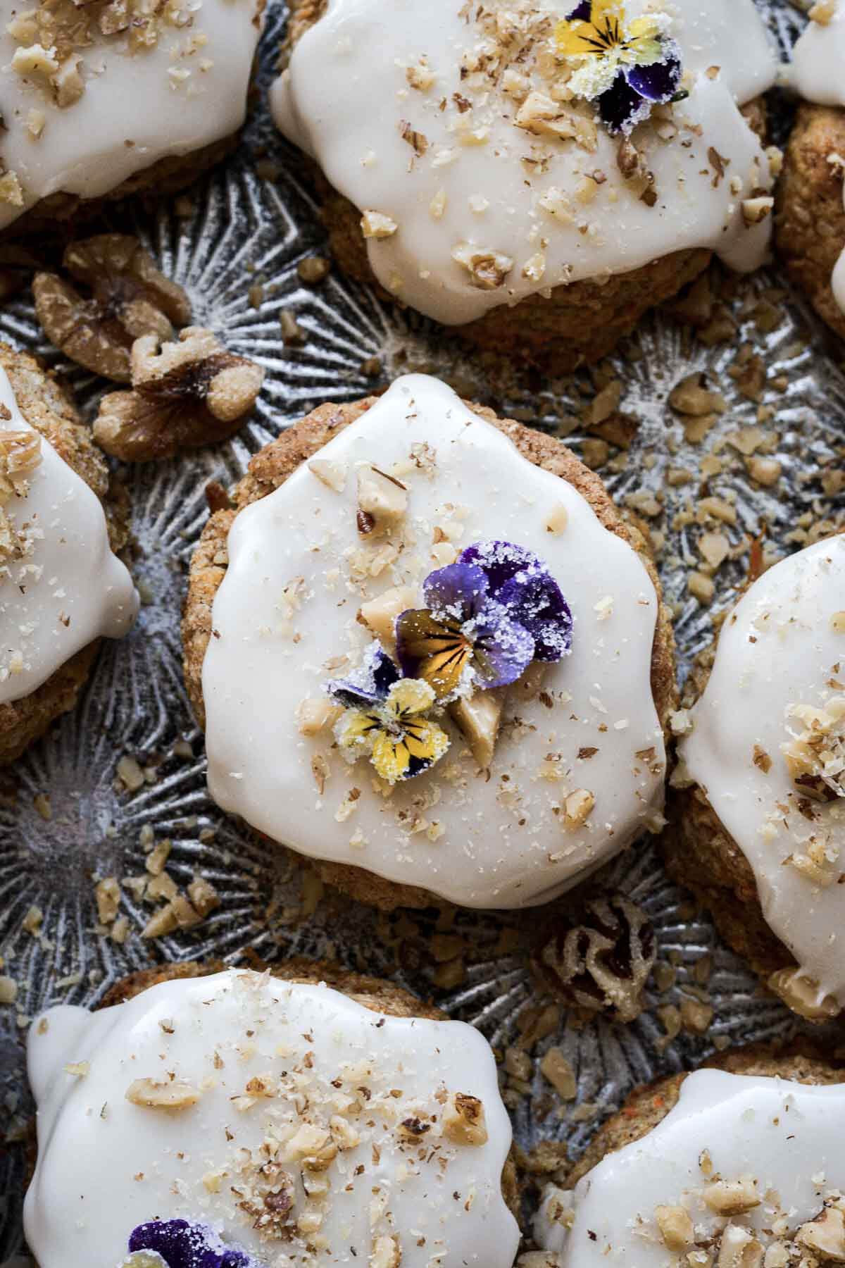 Carrot cake scones with vanilla icing and sugared flowers.