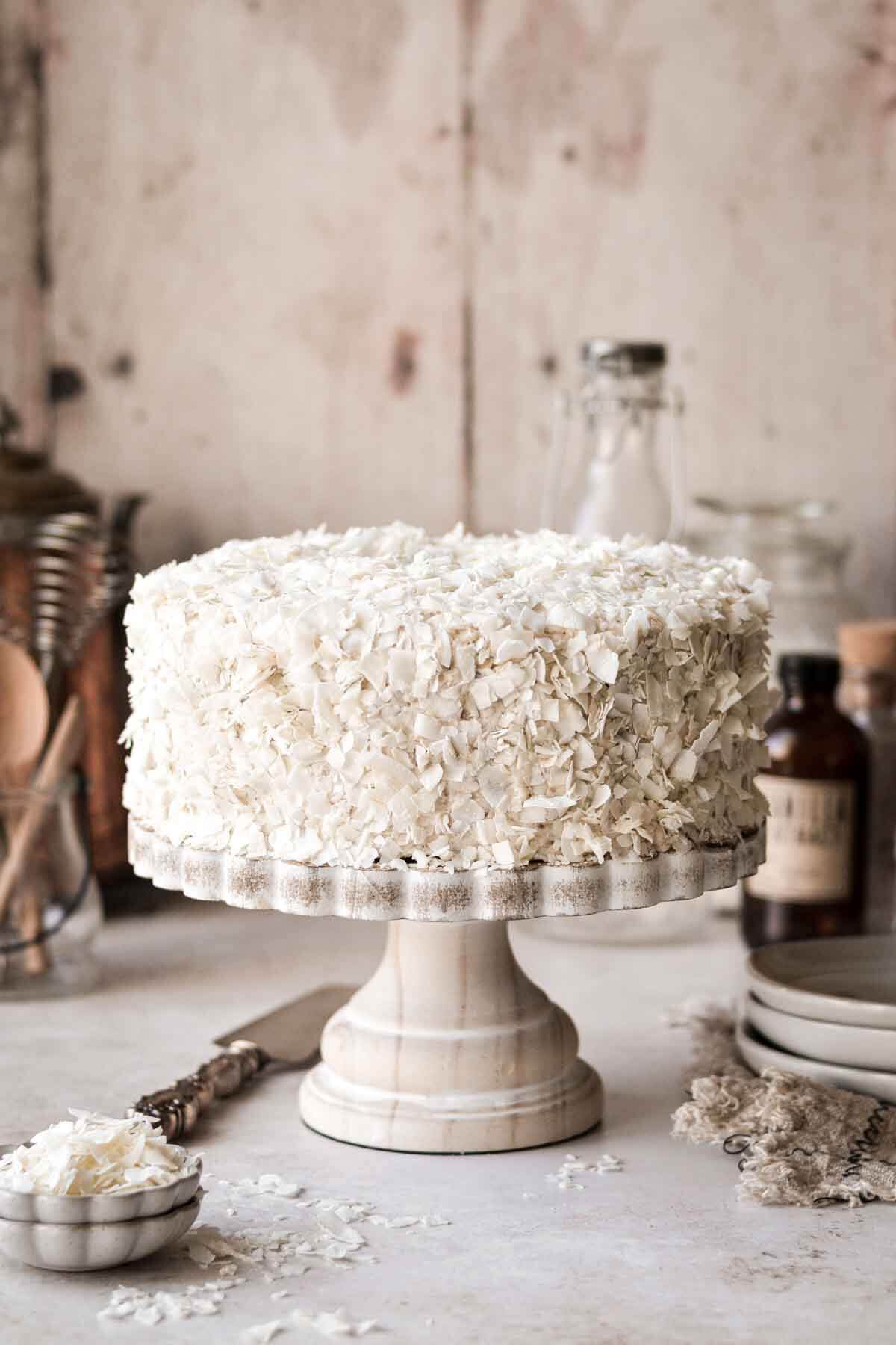 Carrot coconut bundt cake on a white cake stand.