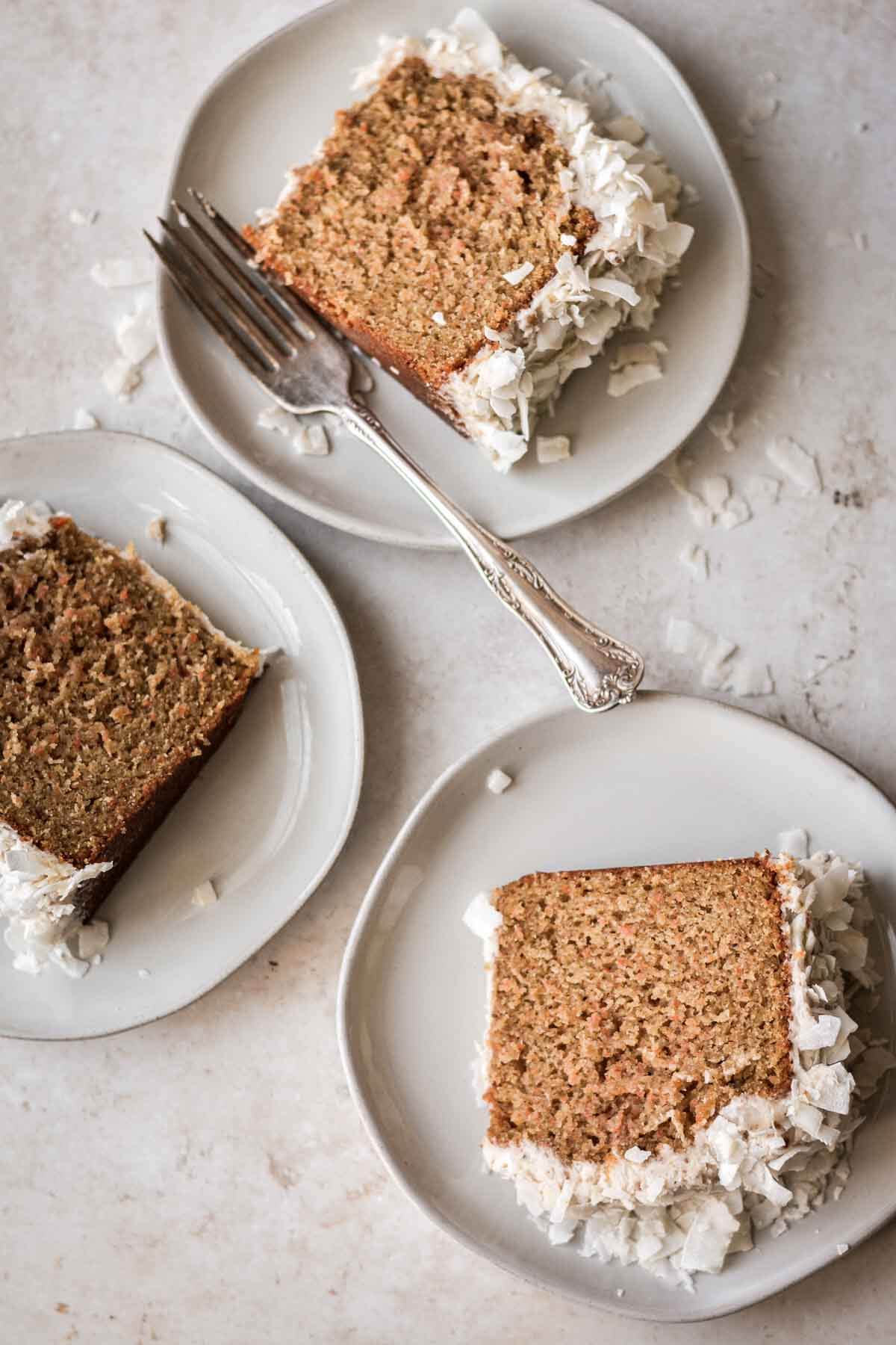 Slices of carrot coconut cake on plates.