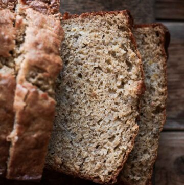Banana bread, sliced on a cutting board.