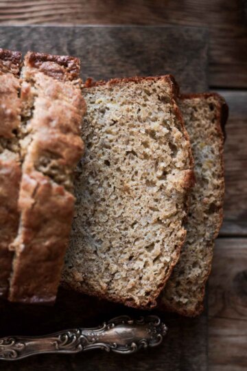 Banana bread, sliced on a cutting board.