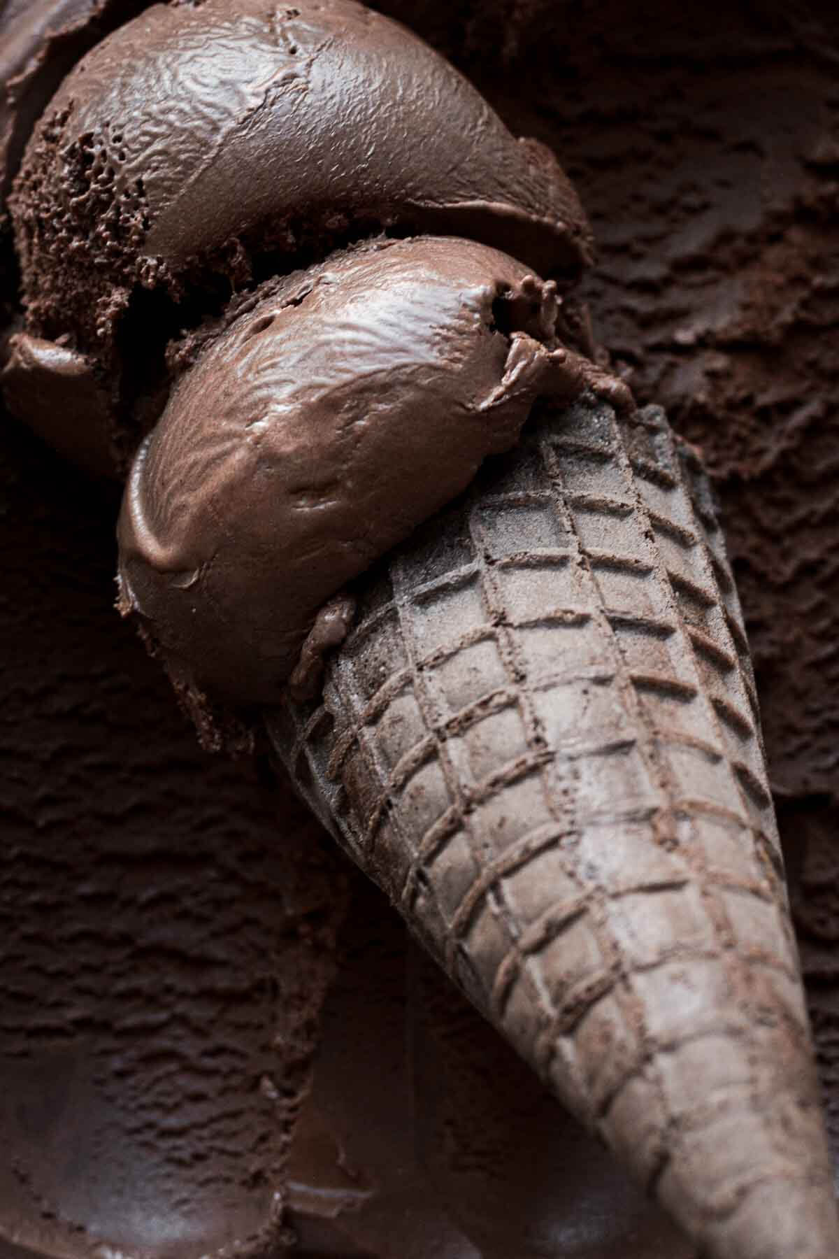 Scoops of double Dutch dark chocolate ice cream in a chocolate ice cream cone.