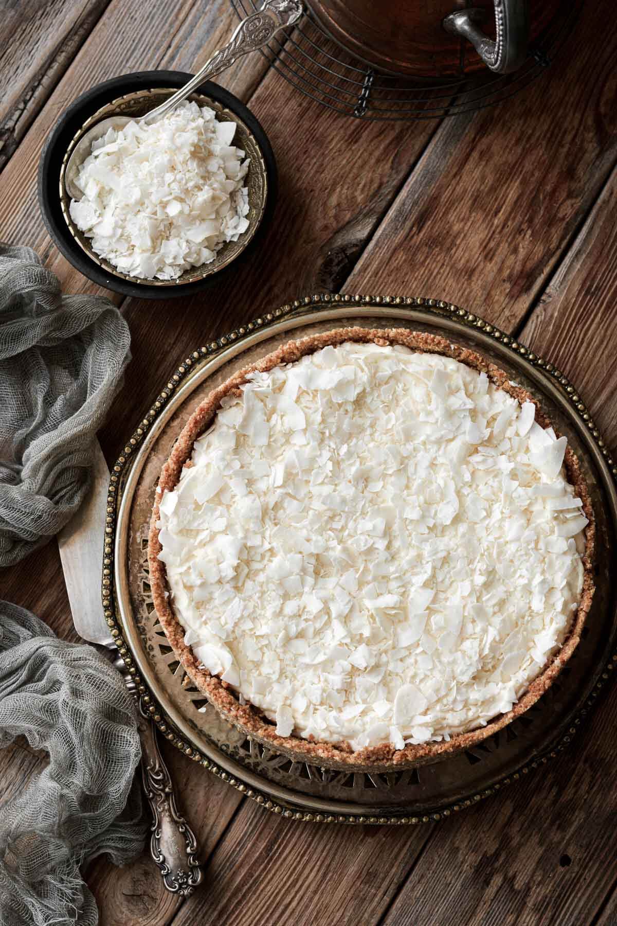 White chocolate coconut cheesecake, sprinkled with coconut flakes on top.