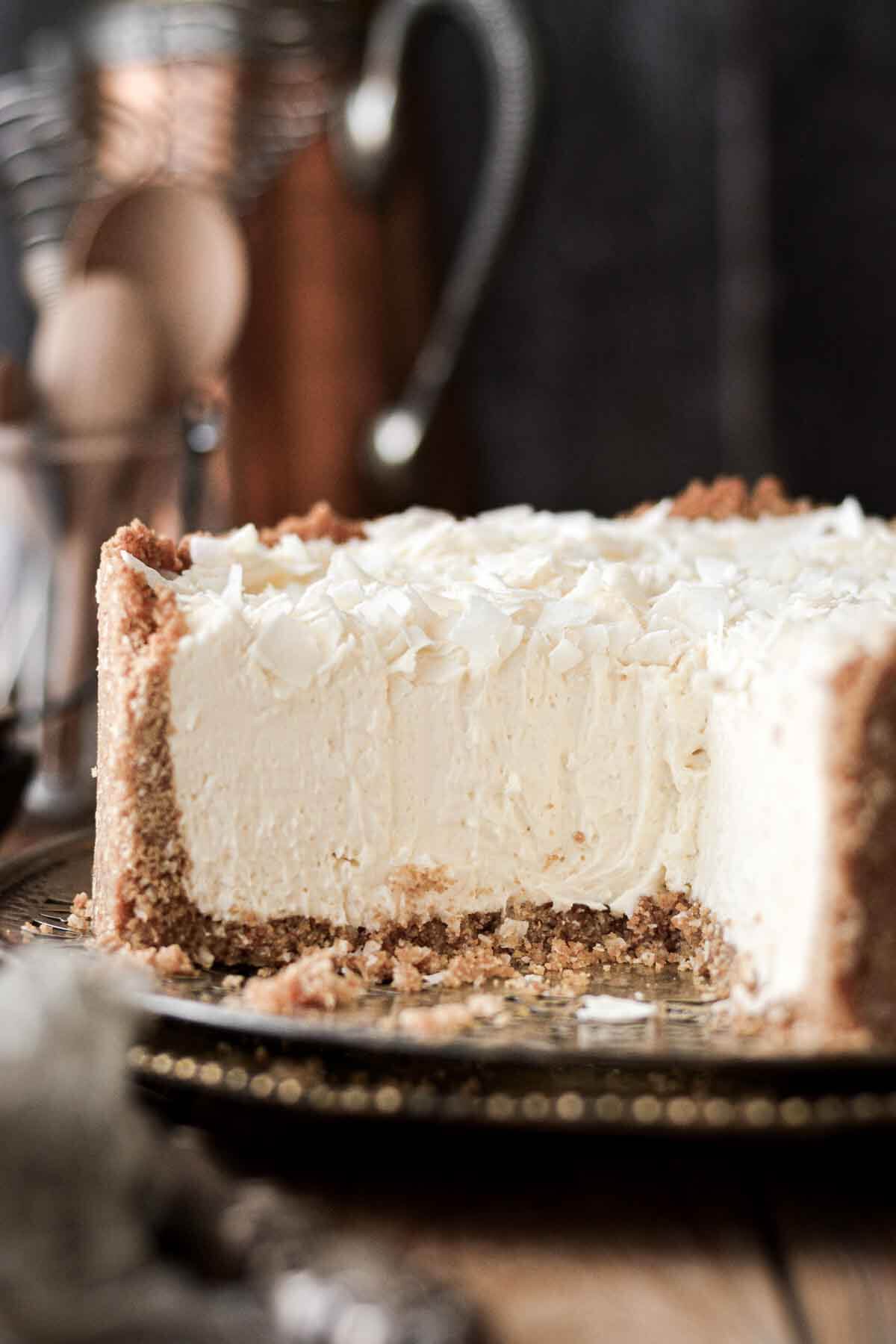White chocolate coconut cheesecake with a slice cut.