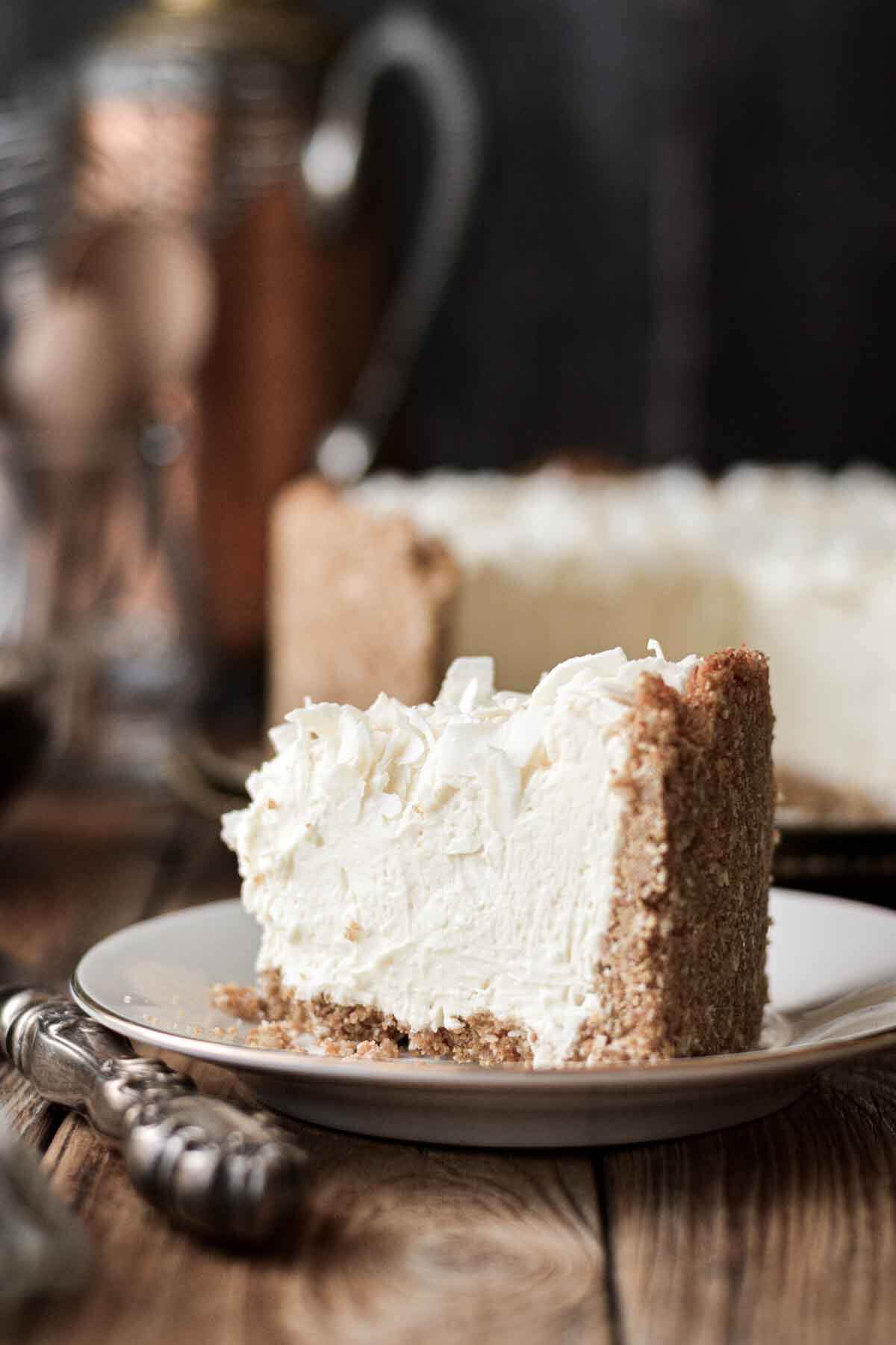 A slice of white chocolate coconut cheesecake on a plate.