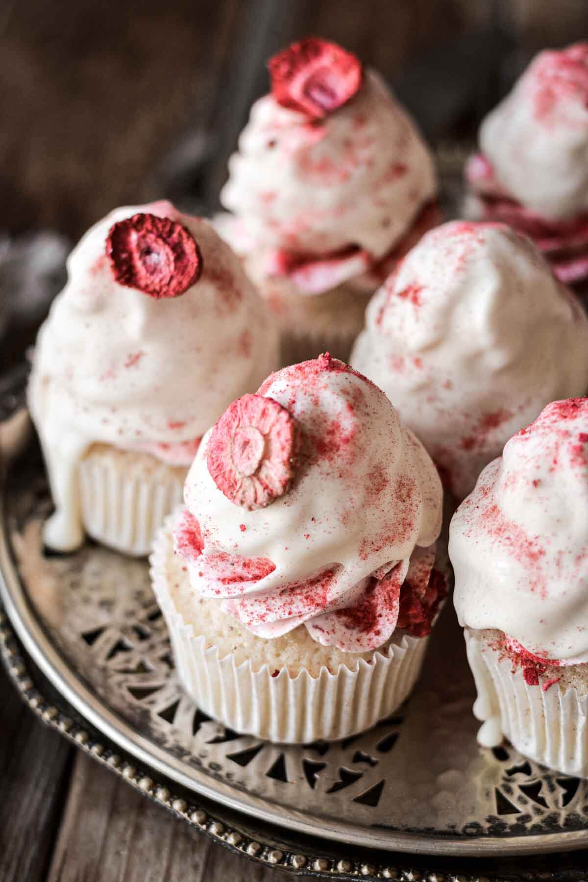 White chocolate strawberry cupcakes decorated with freeze dried strawberries.