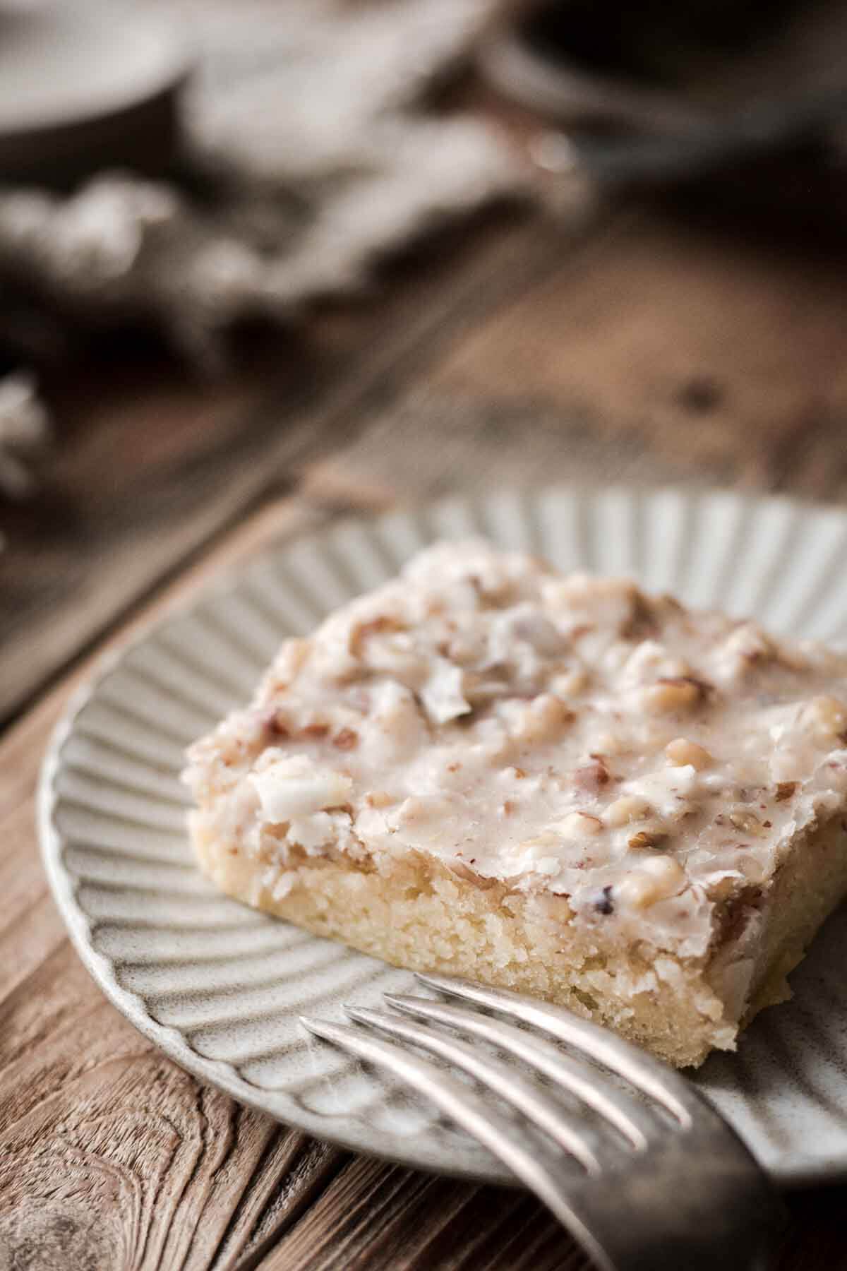 A slice of white Texas sheet cake on a plate.