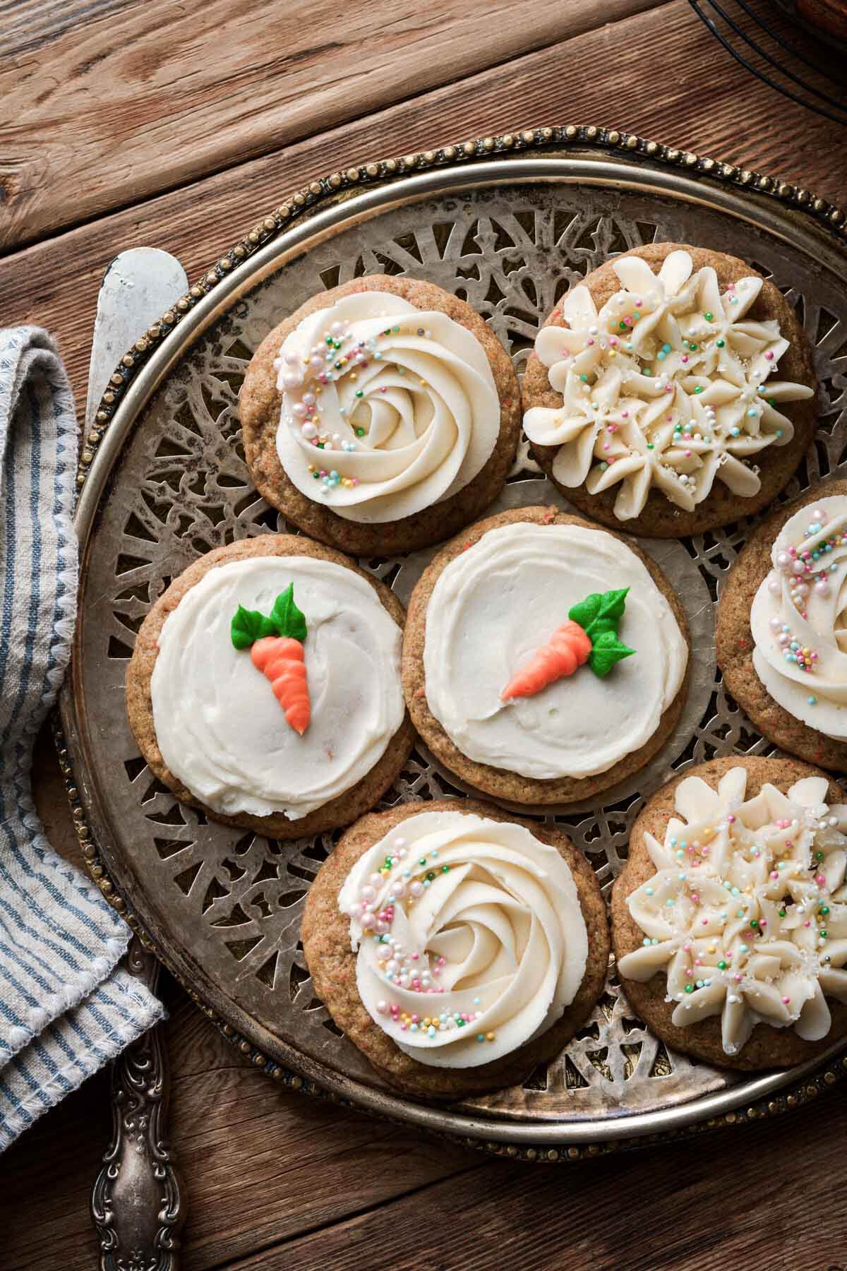 Carrot cake cookies decorated with cream cheese frosting and sprinkles.