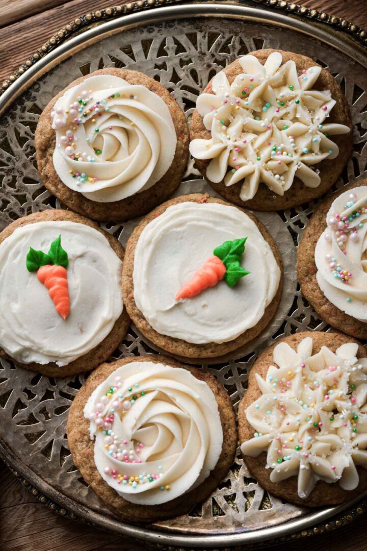 Carrot cake cookies decorated with cream cheese frosting and sprinkles.