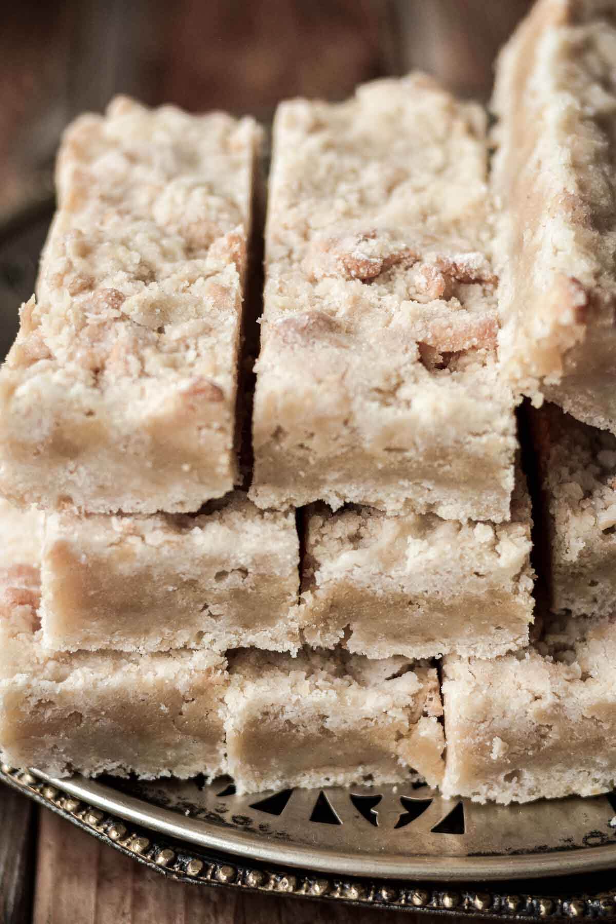 Almond crumb bars stacked on a plate.