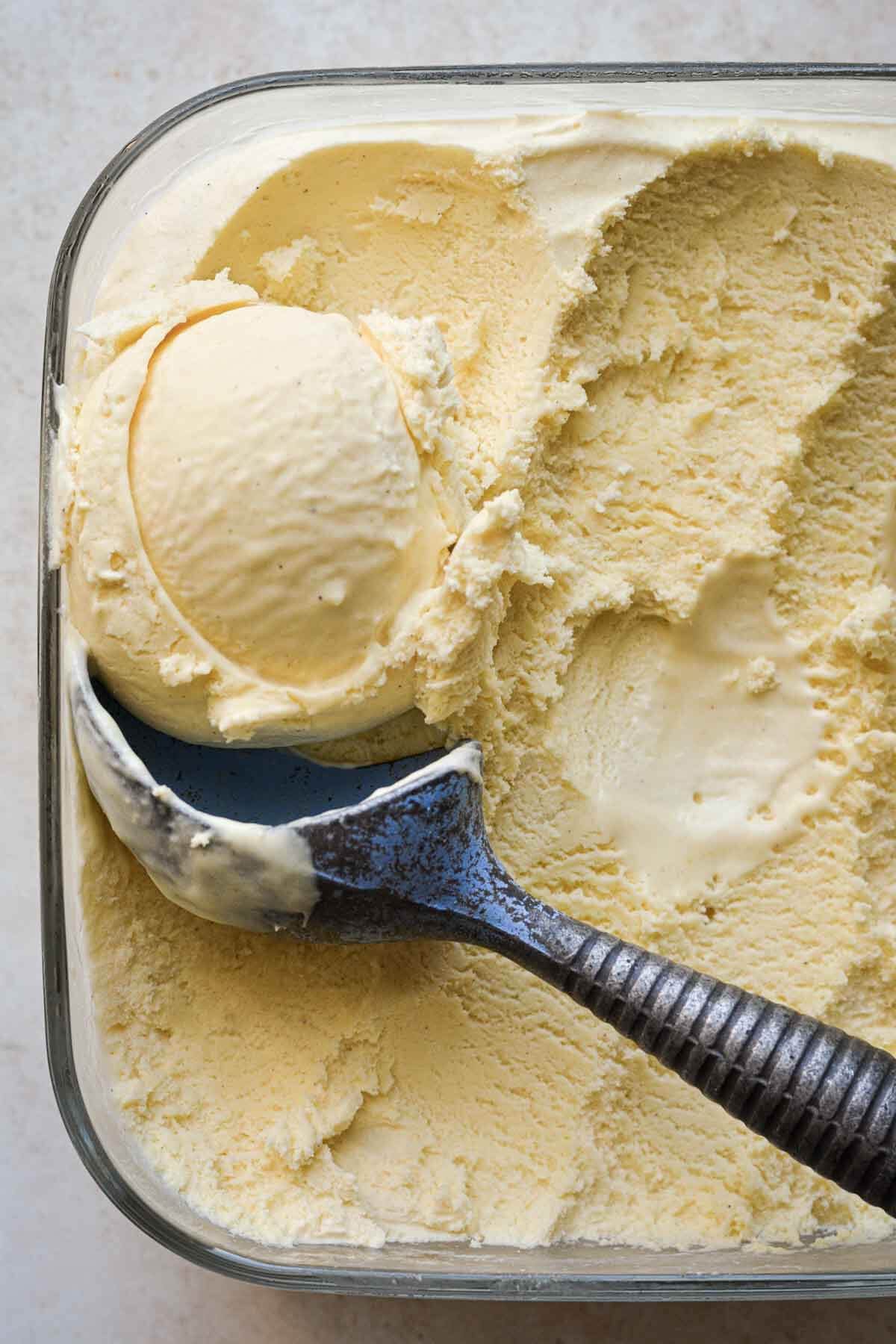 Cardamom mango ice cream with a vintage blue ice cream scoop.