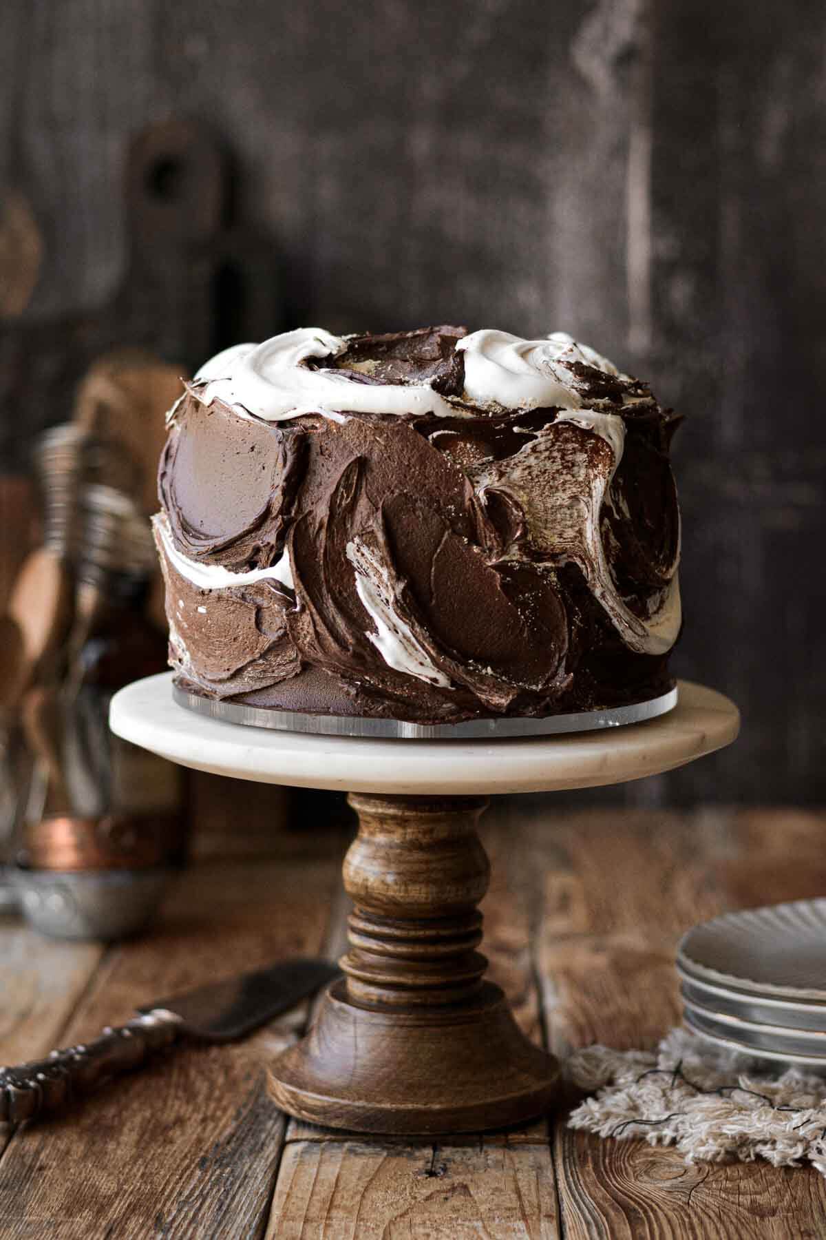 S'mores cake on a wood and marble cake stand.