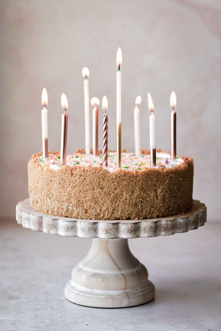 Lighted birthday candles on a sprinkle cheesecake.