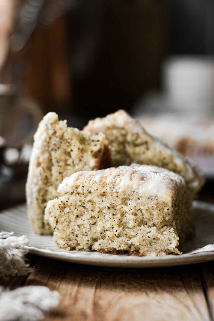 Mini earl grey honey scones with lemon icing, stacked on a plate.
