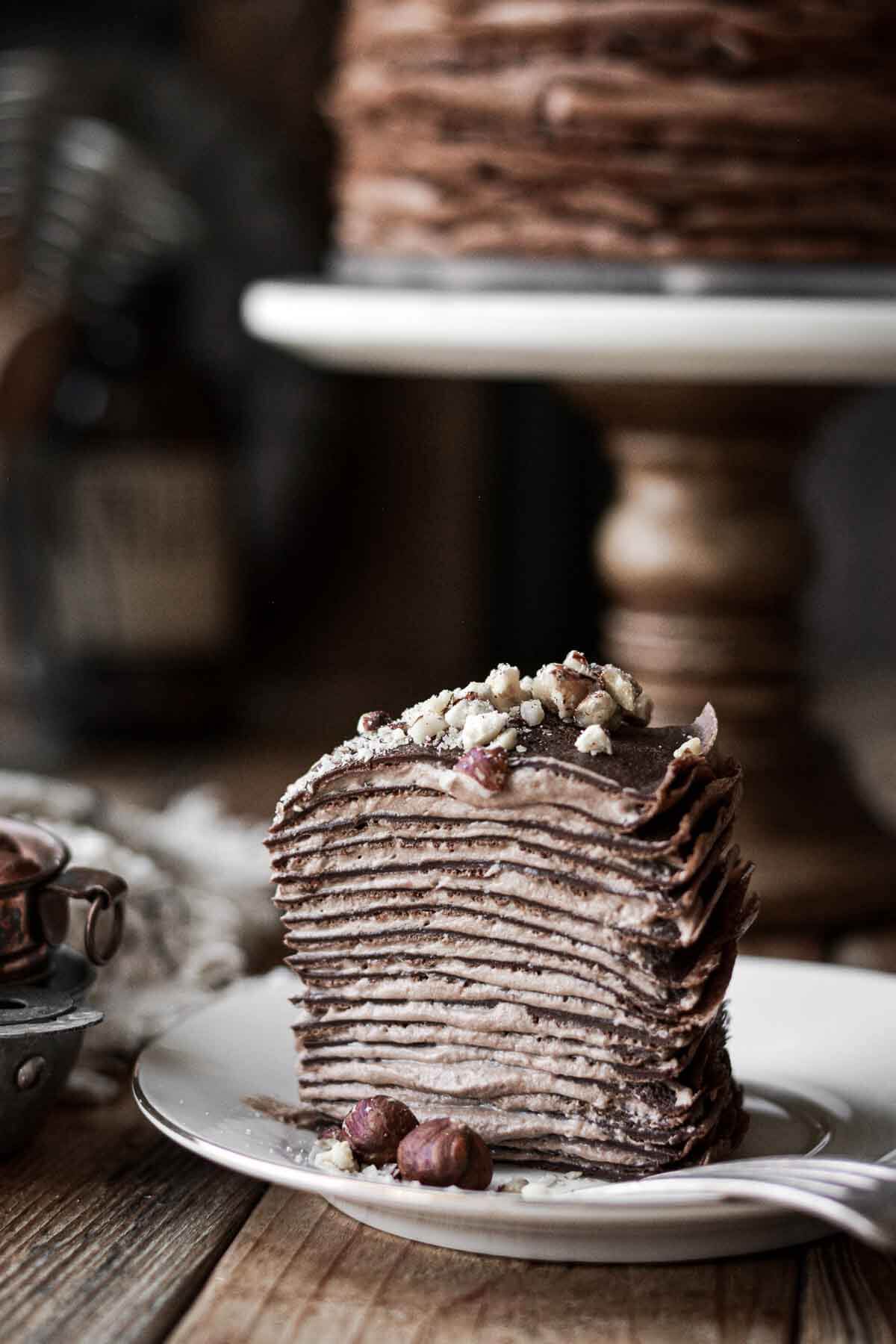 Slice of chocolate hazelnut crepe cake on a plate.
