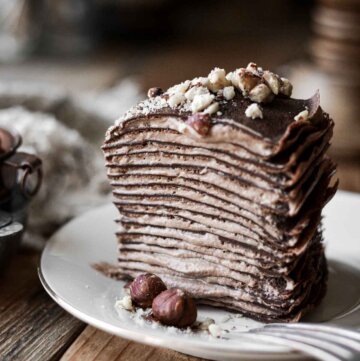 Slice of chocolate hazelnut crepe cake on a plate.