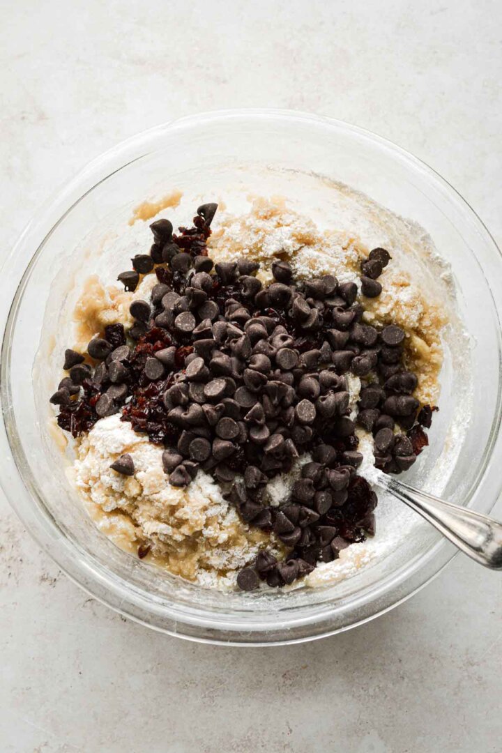 Step 3 for making cherry chocolate chip biscotti - adding chocolate chips and dried cherries.