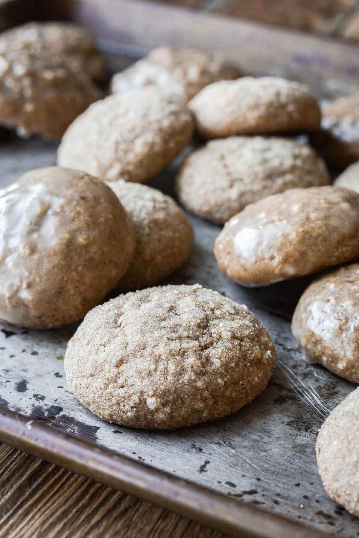 Lebkuchen on a baking sheet, some coated in sugar and some with a lemon glaze.