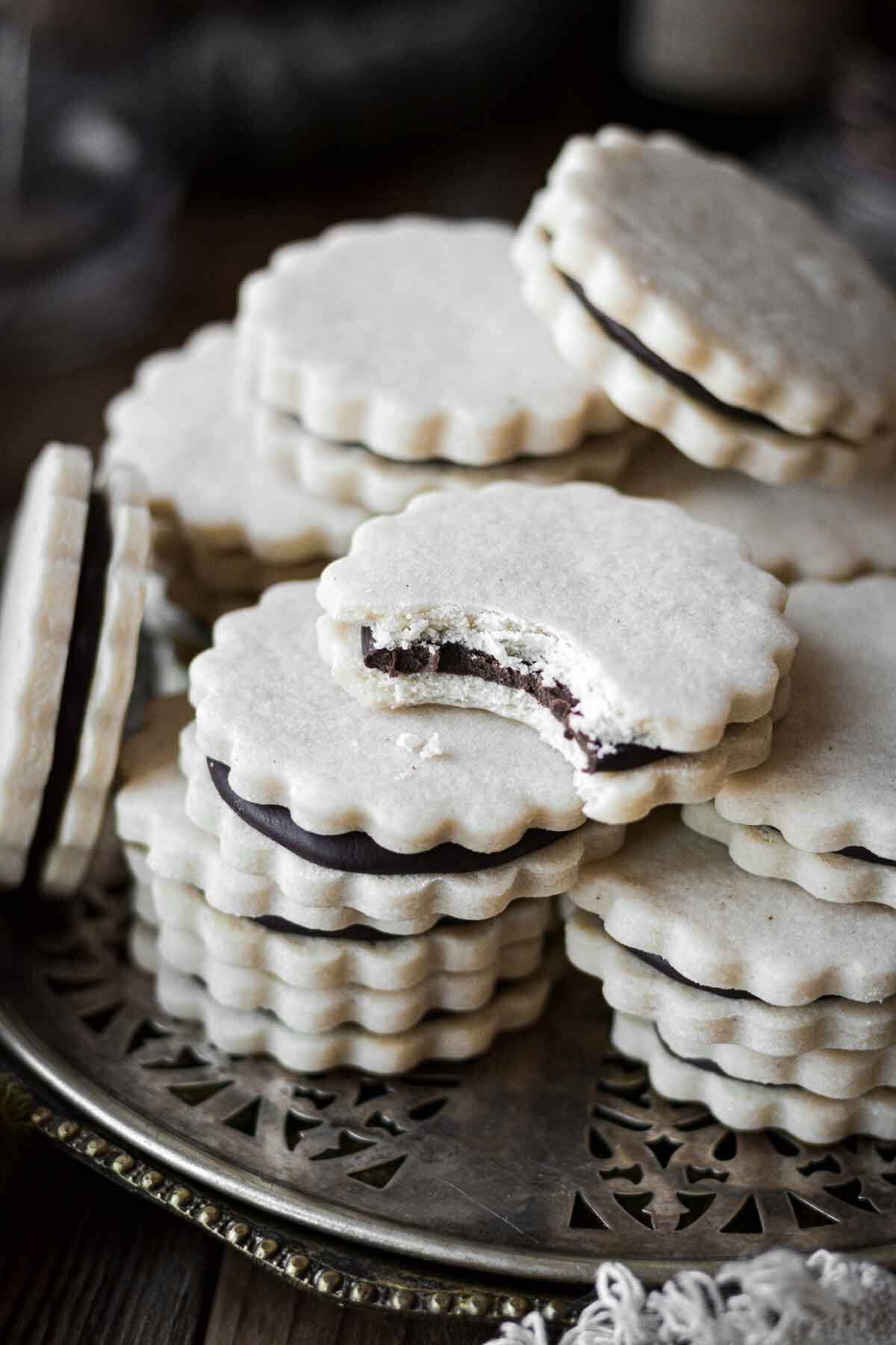 Anise chocolate sandwich cookies, stacked on a silver tray.