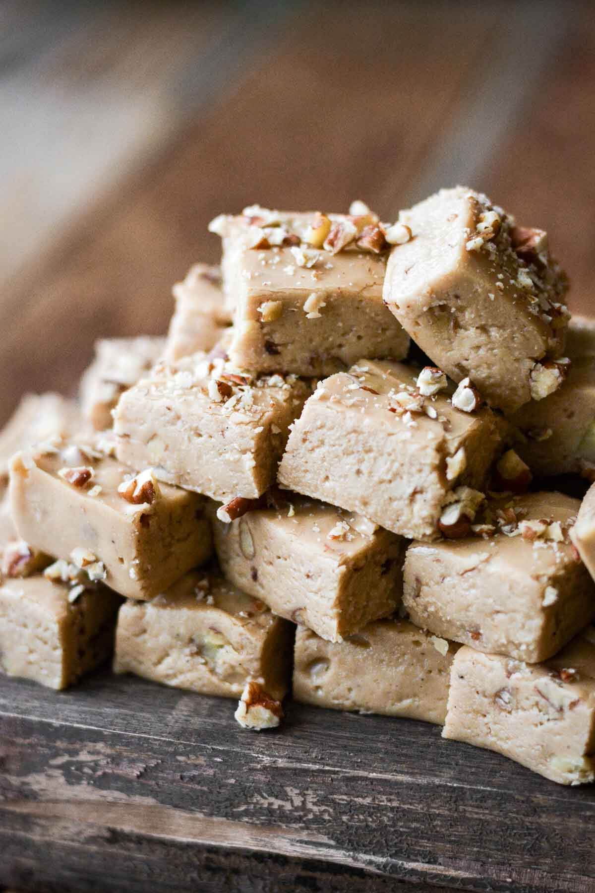 Penuche fudge stacked on a wooden board.