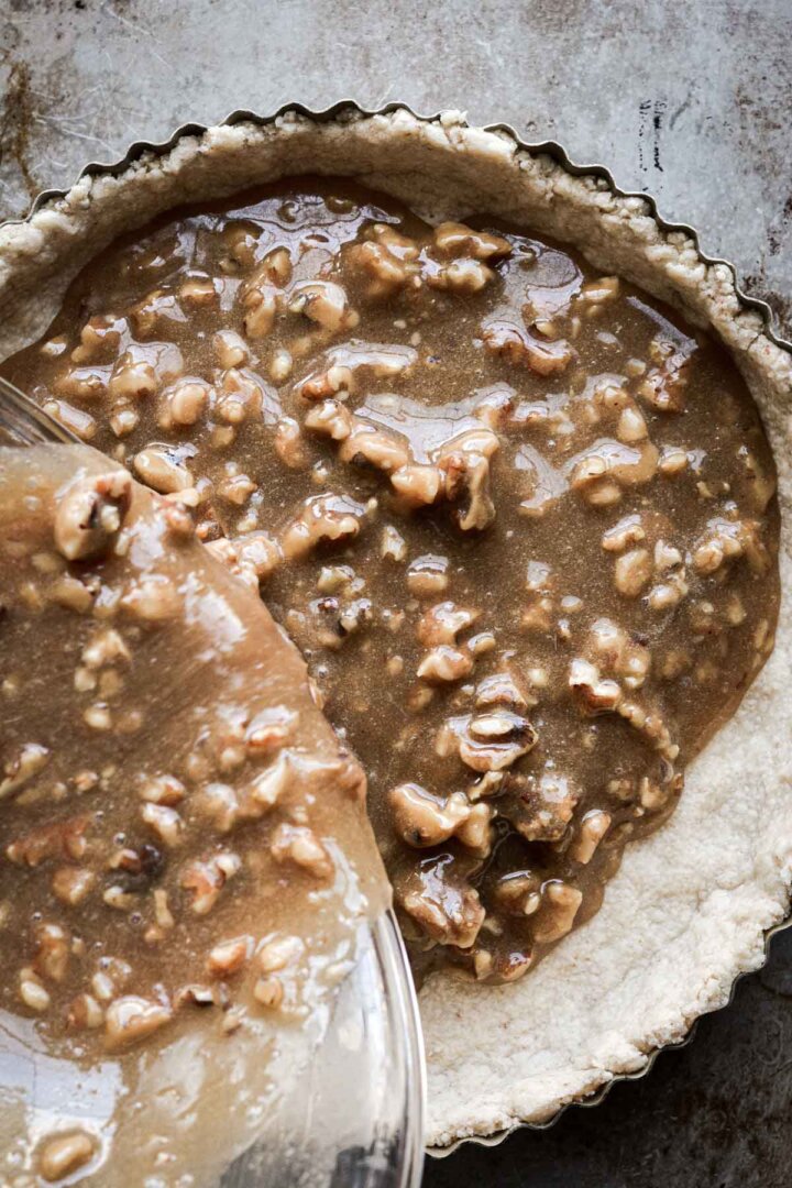 Step 6 for making walnut pie - pouring filling into crust.