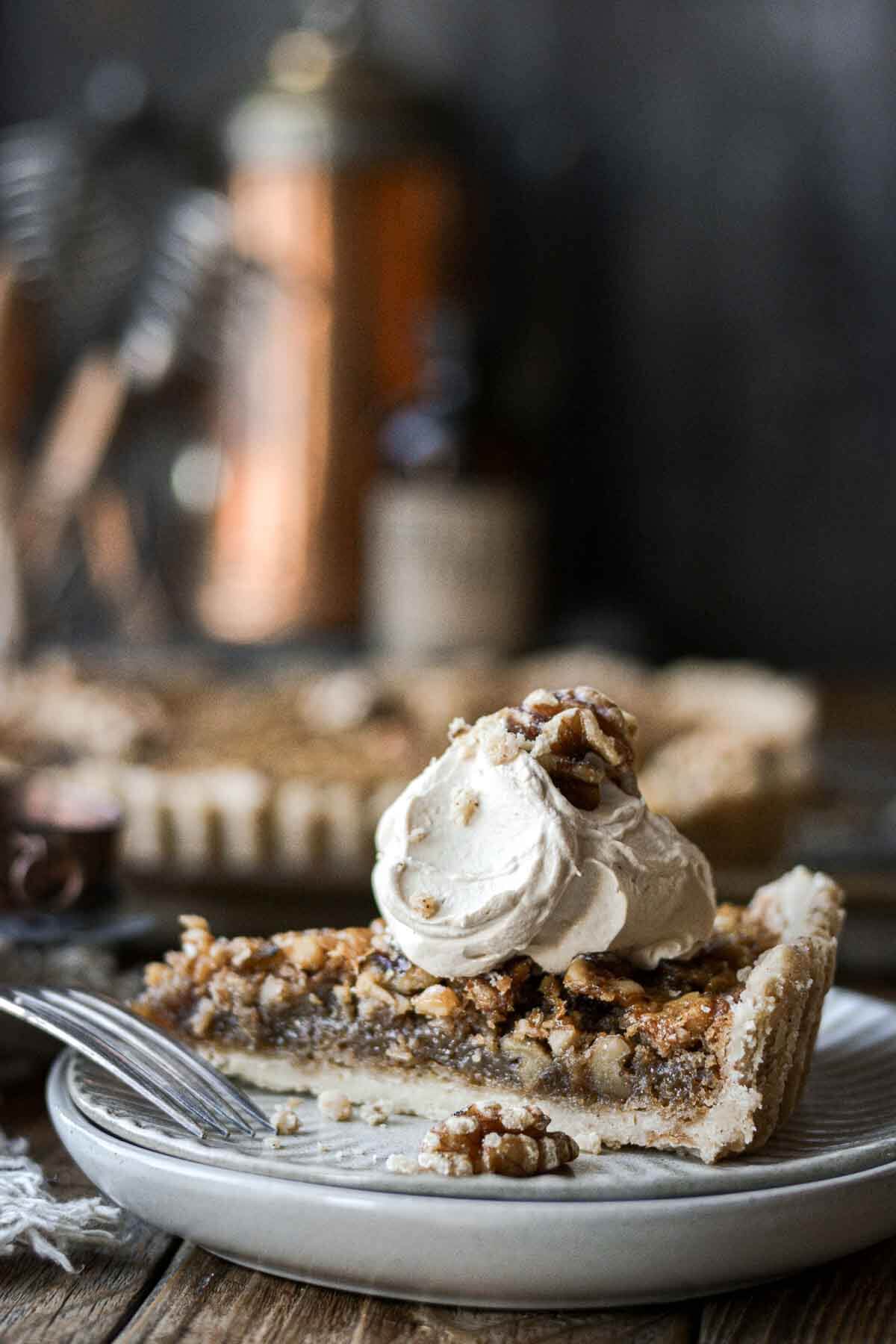 Slice of walnut pie topped with coffee whipped cream.