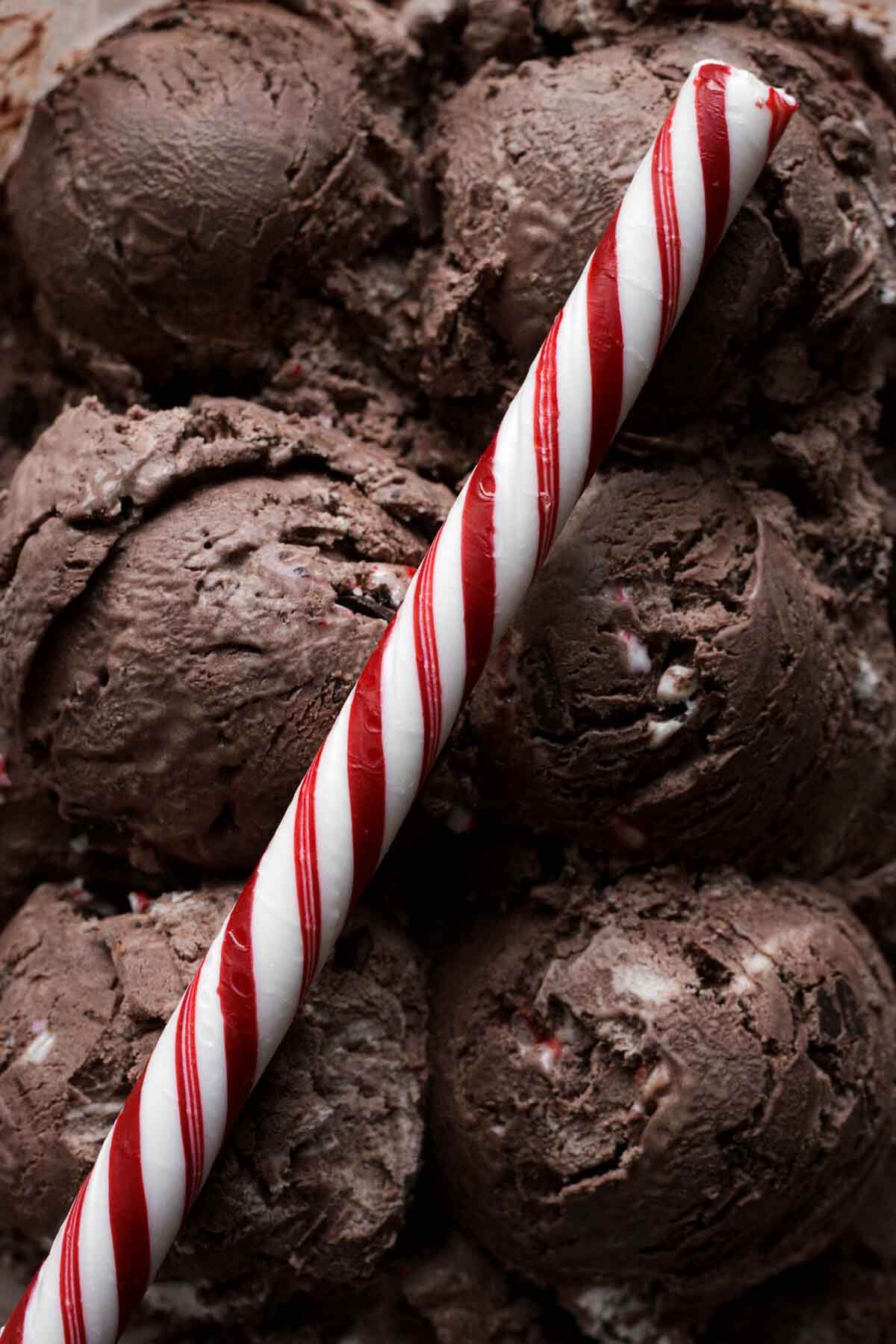 Peppermint stick on top of scoops of chocolate peppermint ice cream.
