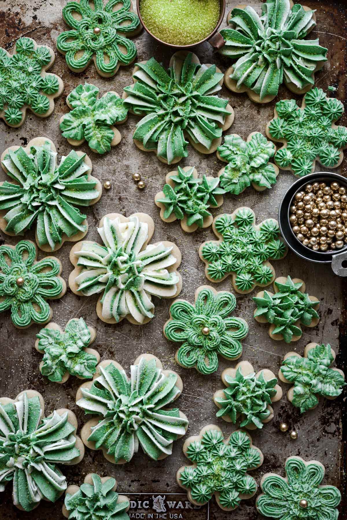 Four leaf clover cutout cookies decorated with green and white buttercream for St Patrick's Day.