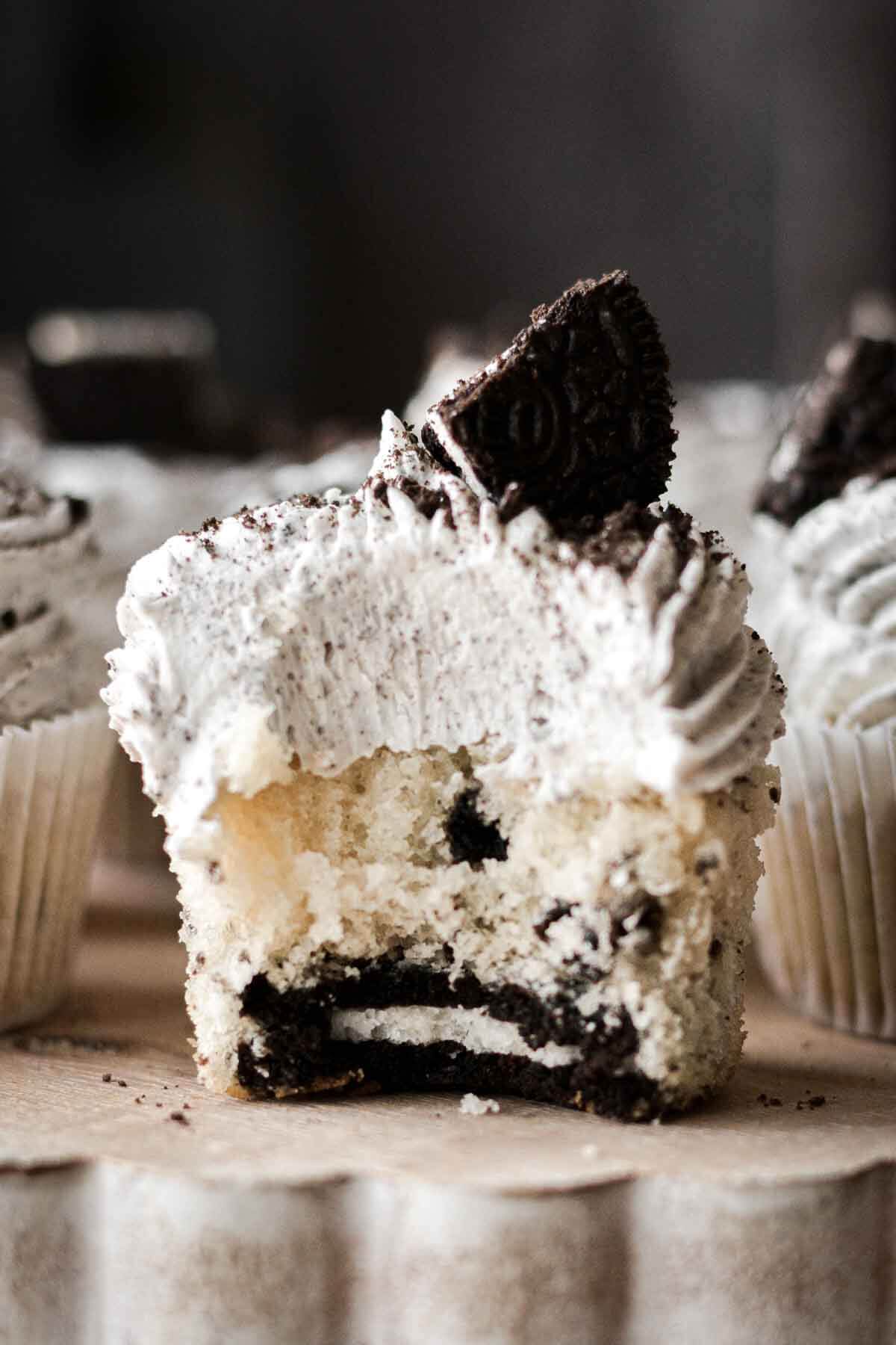 Cookies and cream cupcake with a bite taken.