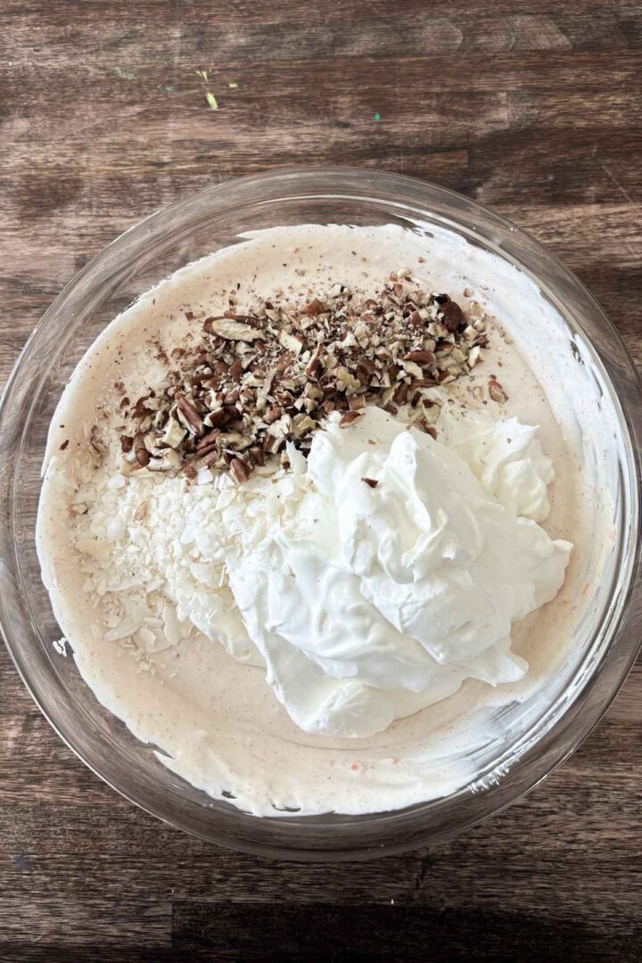 Step 5 for making carrot cake ice cream - adding whipped cream, pecans and coconut.