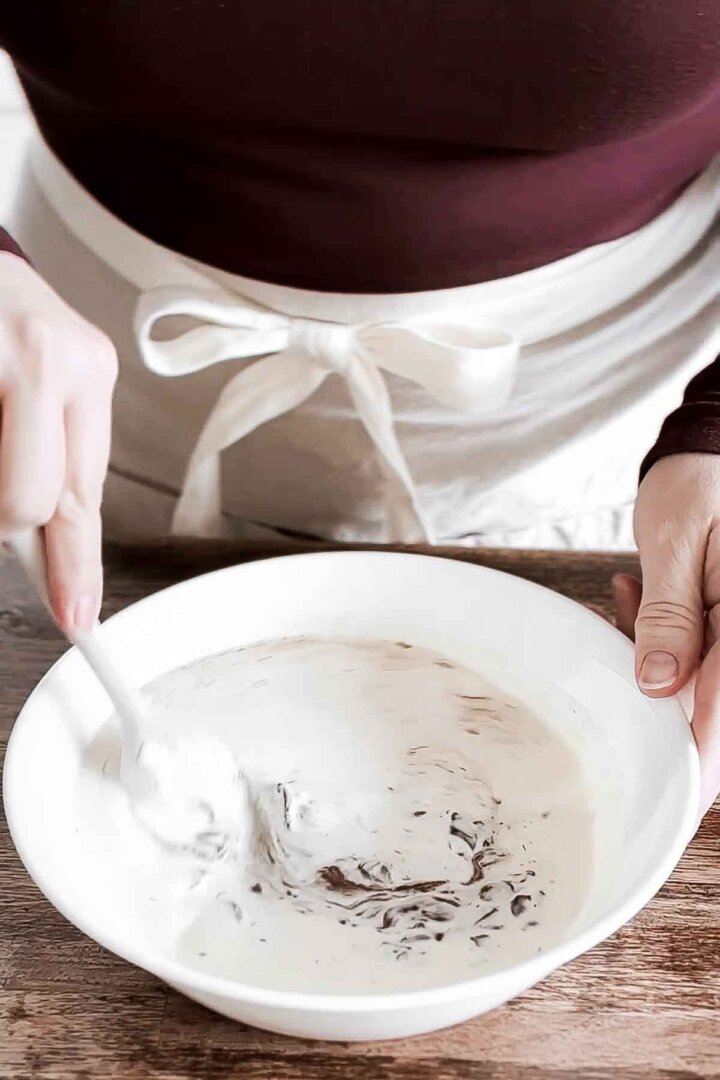 Stirring together cream and chocolate.