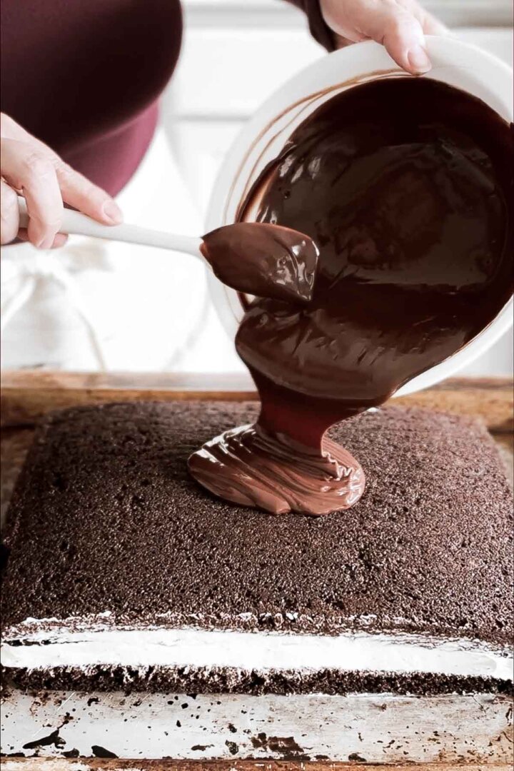Pouring chocolate ganache onto cake.