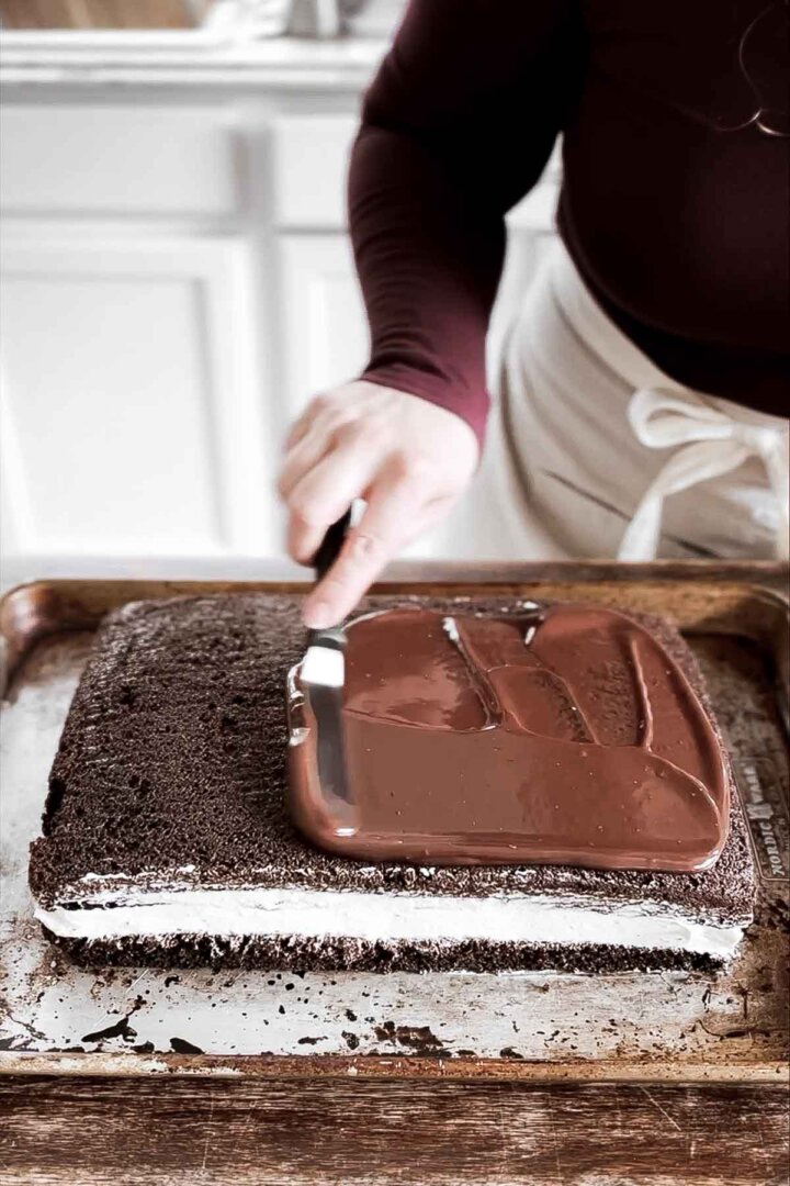 Spreading chocolate ganache over cake.