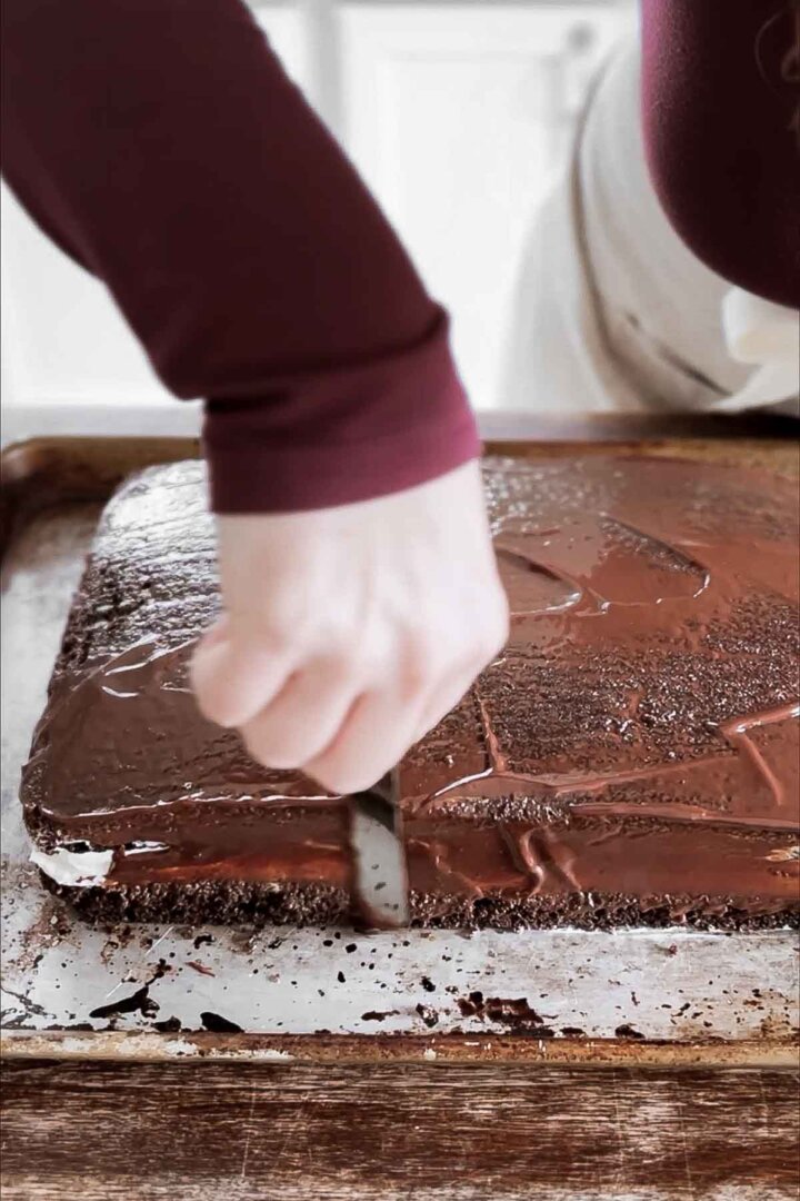Spreading chocolate ganache over cake.